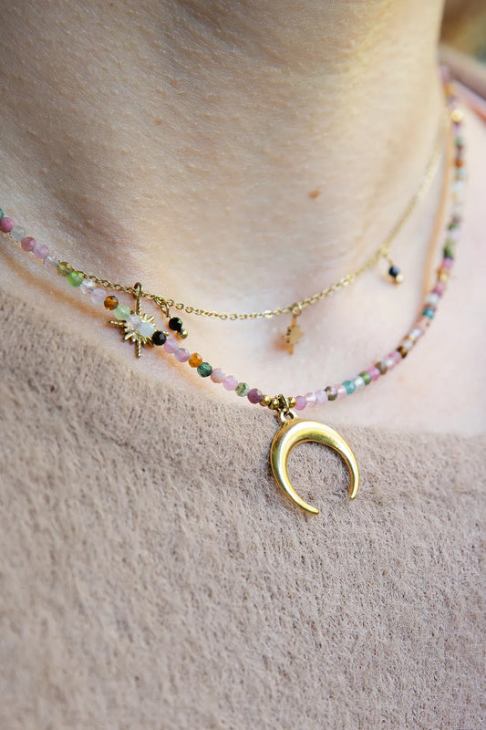 CZAR KSIĘŻYCA - NASZYJNIK Z KOLOROWEGO TURMALINU Z KSIĘŻYCEM. Naszyjnik z kolorowymi koralikami turmalinu i złotym księżycem na delikatnej łańcuszku, na tle skóry.