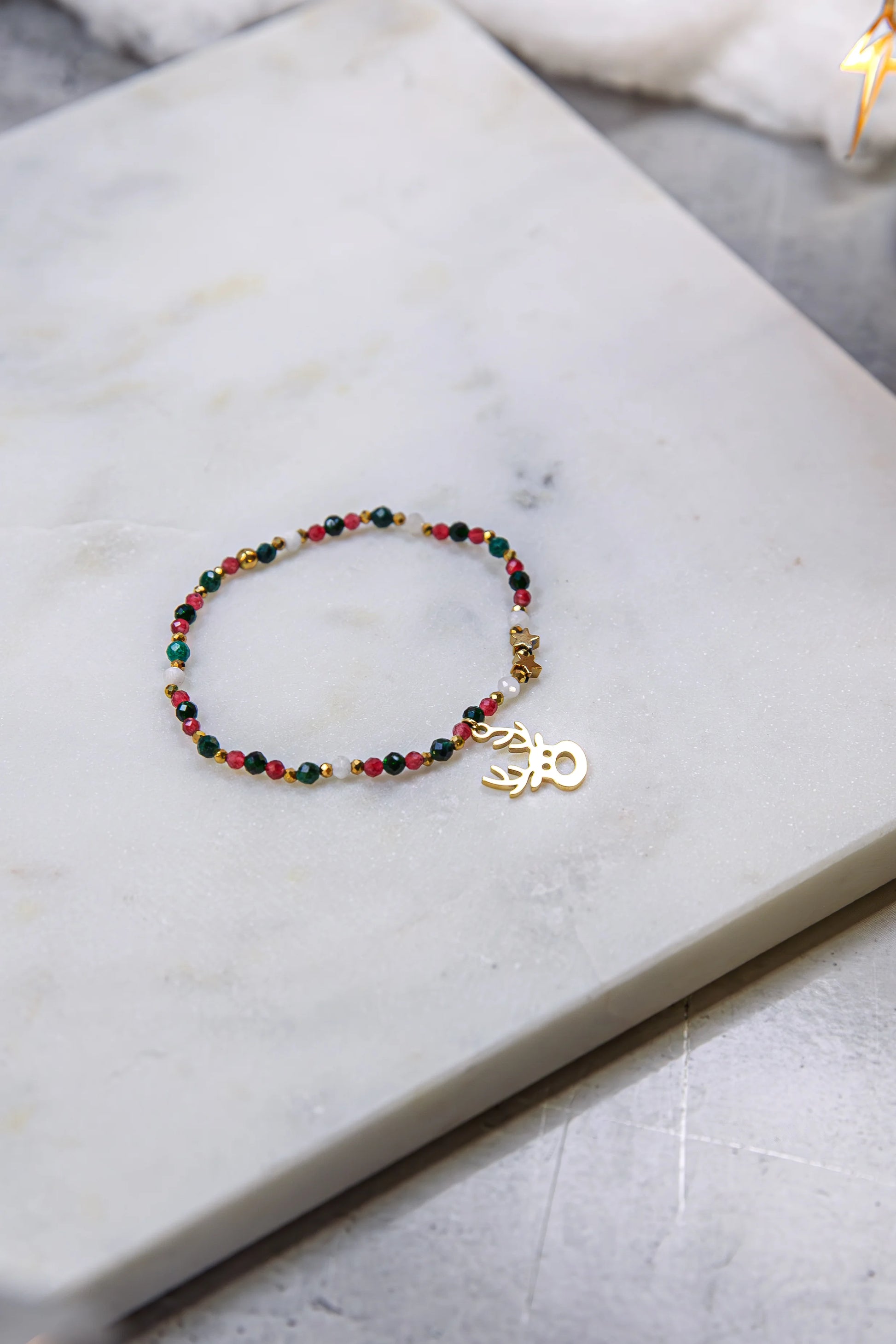 Zbliżenie (makro) ukazujące teksturę autentycznych kamieni naturalnych: głęboki, winny burgund chalcedonu, żywa zieleń Szmaragdu Nilu i metaliczny blask hematytu.