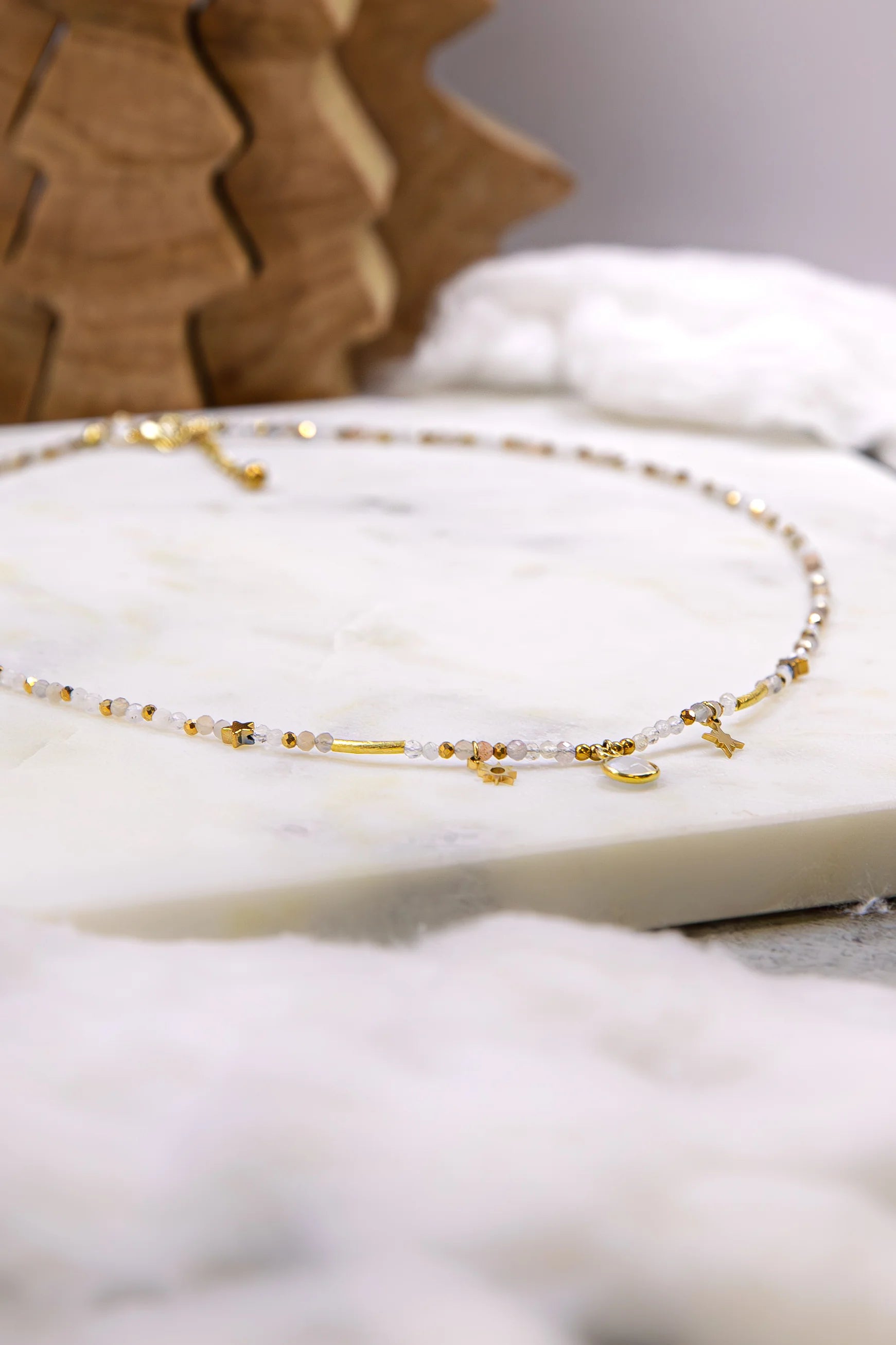 Zbliżenie (makro) ukazujące teksturę autentycznych kamieni naturalnych w naszyjniku: iskrzący kamień słoneczny, transparentny cytryn i kojący zielony jadeit z elementami masy perłowej.