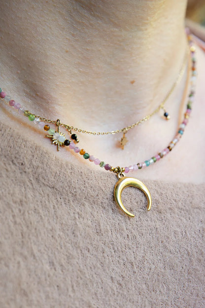 CZAR KSIĘŻYCA - NASZYJNIK Z KOLOROWEGO TURMALINU Z KSIĘŻYCEM. Naszyjnik z kolorowymi koralikami turmalinu i złotym księżycem na delikatnej łańcuszku, na tle skóry.