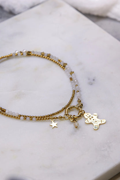 Widok z góry (flat lay) na kompozycję z personalizowanym naszyjnikiem i zestawem świątecznych zawieszek. Ręcznie tworzona biżuteria marki Pati Linka na tle marmuru i betonu.