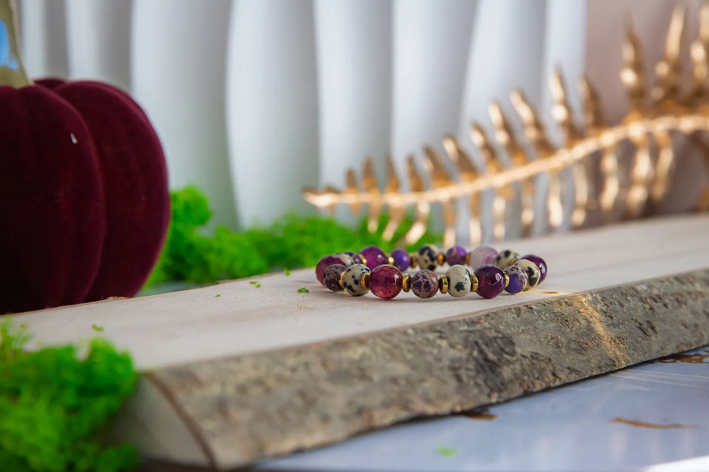KRÓLEWSKA INTUICJA - BRANSOLETKA Z JASPISU CESARSKIEGO I FIOLETOWEGO AGATU, widoczna na drewnianym tle z zielonym mchem i złotym dekoracyjnym elementem w tle.