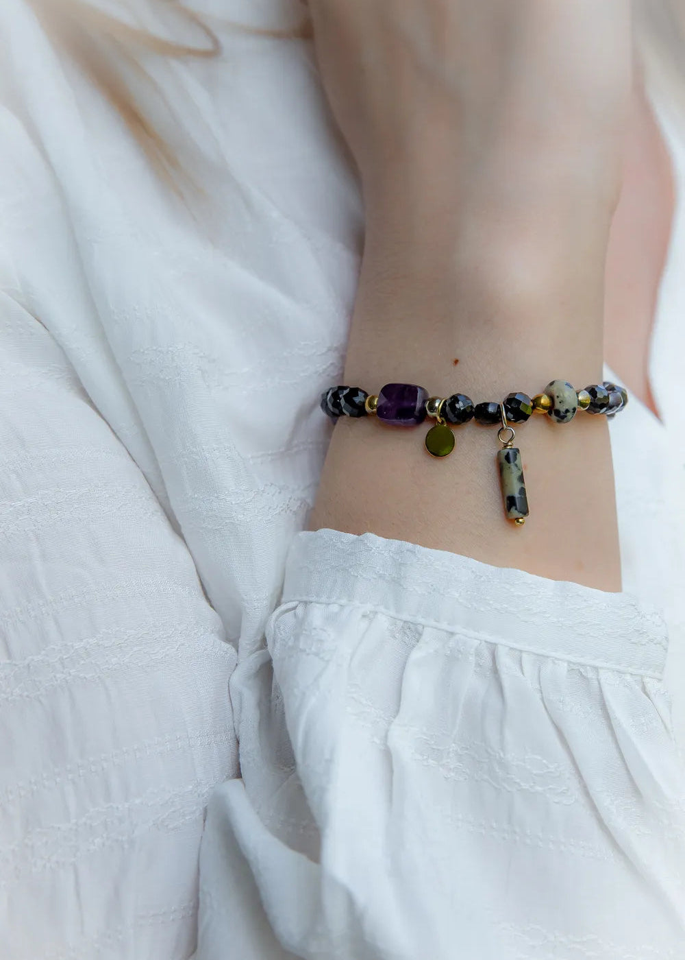 Królewska Ochrona Bransoletka Z Turmalinu I Ametystu Kamienie: fasetowany turmalin i dalmatyńska jaspis na białym tle.