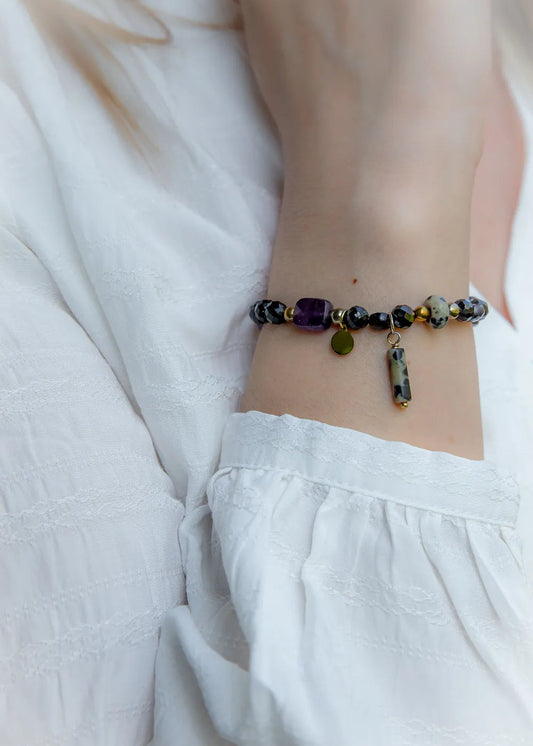 Królewska Ochrona Bransoletka Z Turmalinu I Ametystu Kamienie: fasetowany turmalin i dalmatyńska jaspis na białym tle.