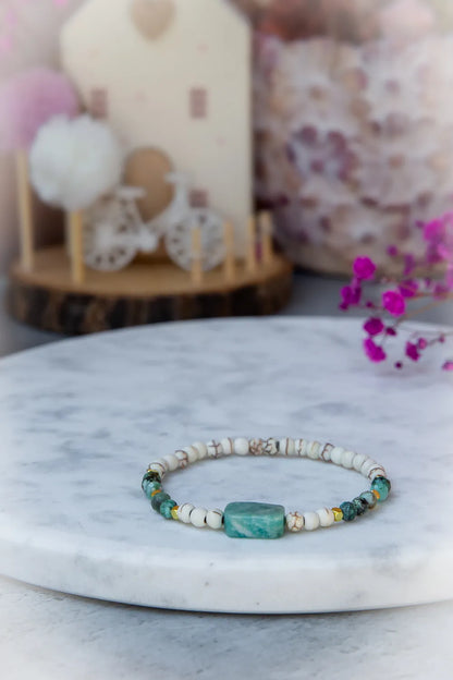 Morska Bryza Bransoletka Kamienie ze szczyptą złota i surowego turkusu, na tle pastelowych ozdób.