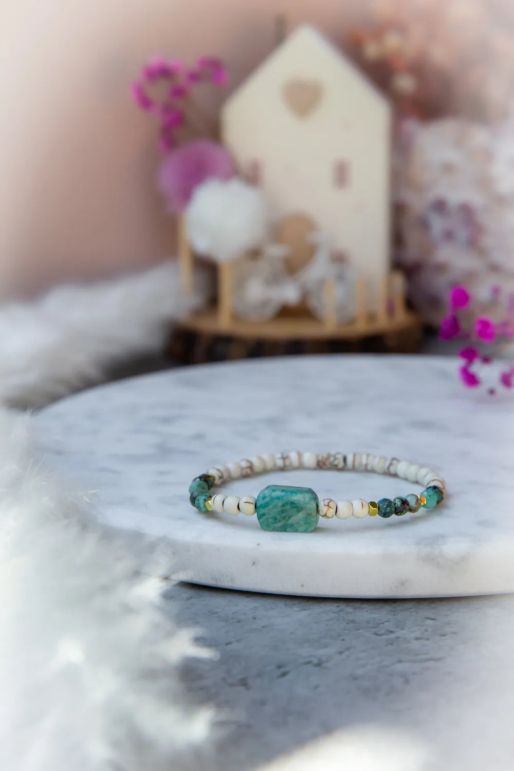 Morska Bryza Bransoletka Z Kamieniami na marmurowej podstawie, z turkusowym kamieniem centralnym i białymi koralikami.