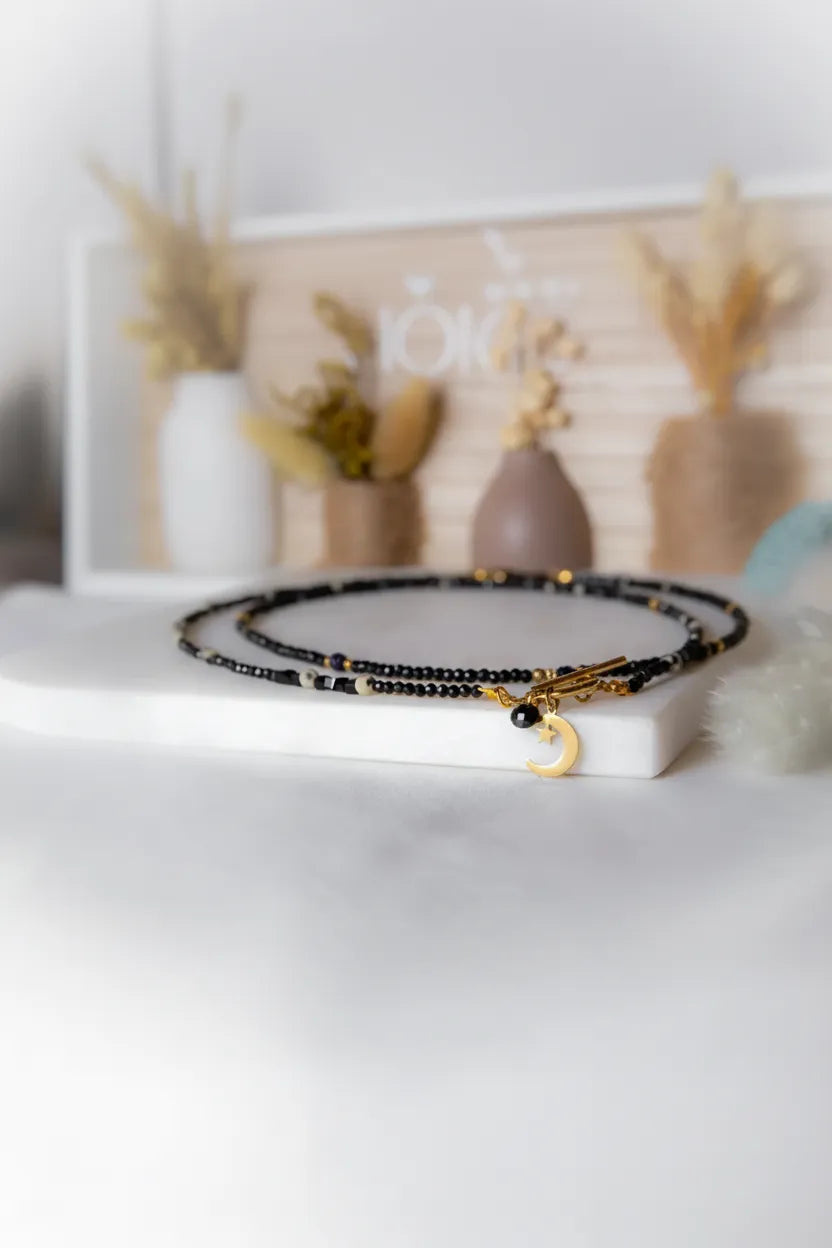 Kolekcja naszyjników Patilinka z czarnych kamieni fasetowanych i złotych elementów, w tym naszyjnik z księżycem, słońcem i sercem. Elegancka biżuteria na każdą okazję.