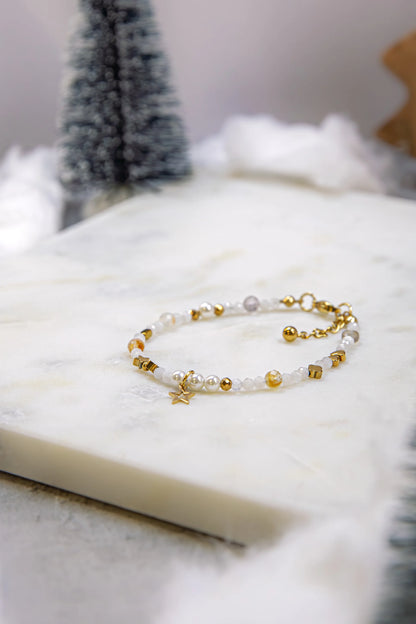 Widok z góry na elastyczną bransoletkę na gumce jubilerskiej. Widoczna harmonijna kompozycja różnorodnych kamieni naturalnych: cytrynu, jadeitu i kamienia słonecznego.