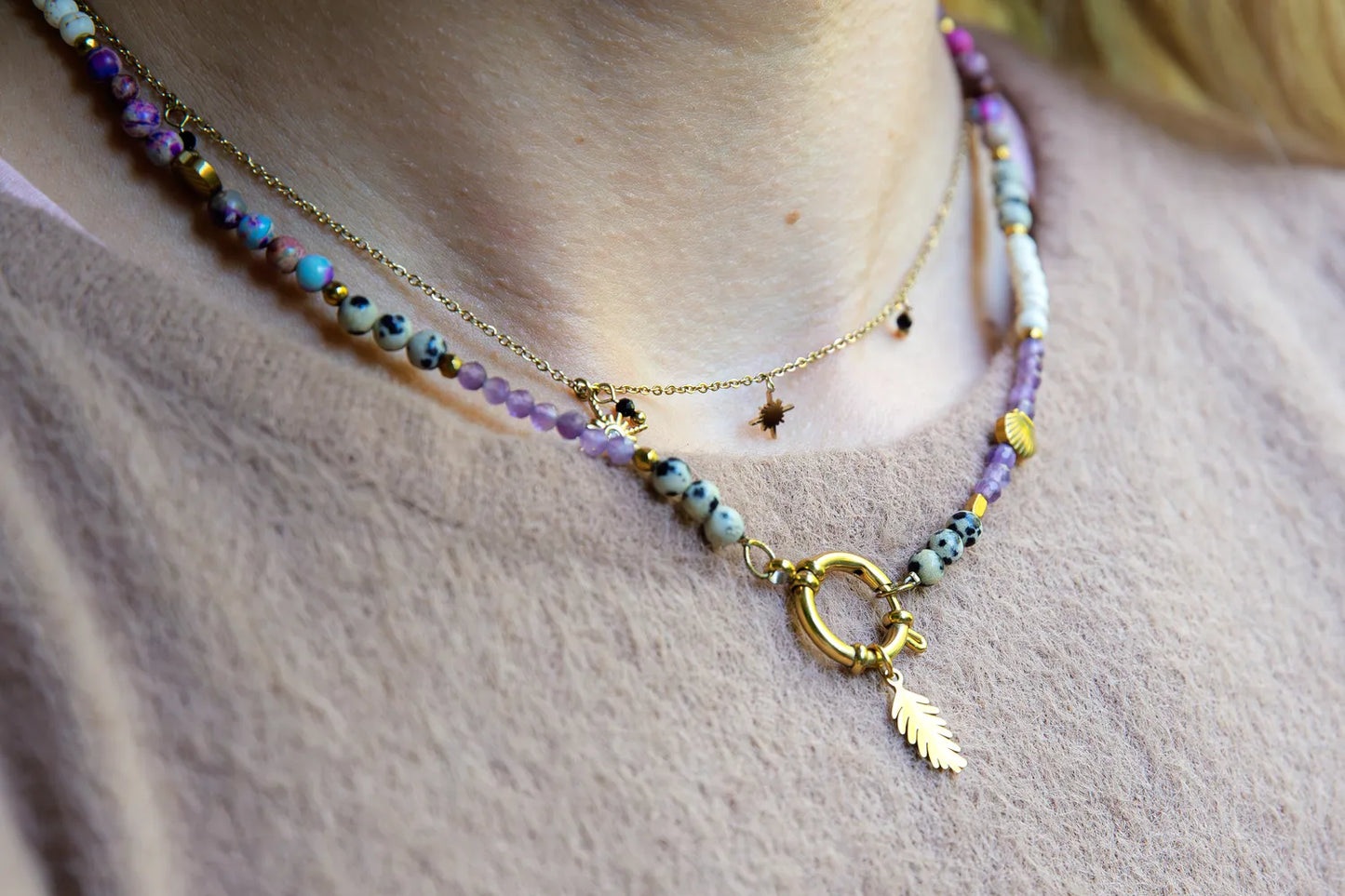 PEŁNIA HARMONII - NASZYJNIK Z AMETYSTU, HOWLITU I JASPISU DALMATYŃSKIEGO. Naszyjnik z kolorowymi kamieniami, w tym ametystami, howlitami i jaspisem dalmatyńskim, na delikatnym łańcuszku. Tło z delikatnej tkaniny.