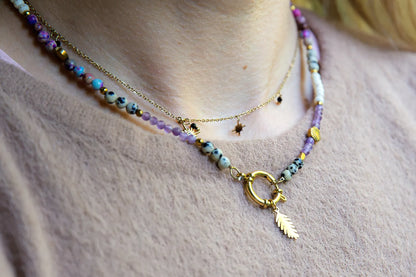 PEŁNIA HARMONII - NASZYJNIK Z AMETYSTU, HOWLITU I JASPISU DALMATYŃSKIEGO. Naszyjnik z kolorowymi kamieniami, w tym ametystami, howlitami i jaspisem dalmatyńskim, na delikatnym łańcuszku. Tło z delikatnej tkaniny.