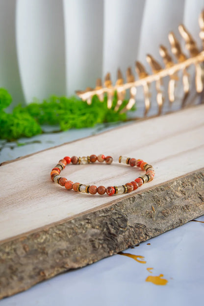 produkt naszyjnik z kolorowymi koralikami i złotym zamkiem na marmurowym tle