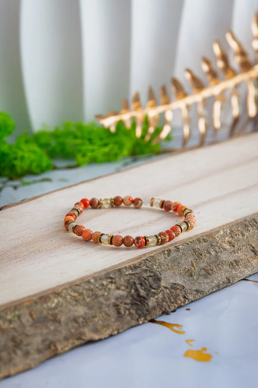 produkt naszyjnik z kolorowymi koralikami i złotym zamkiem na marmurowym tle