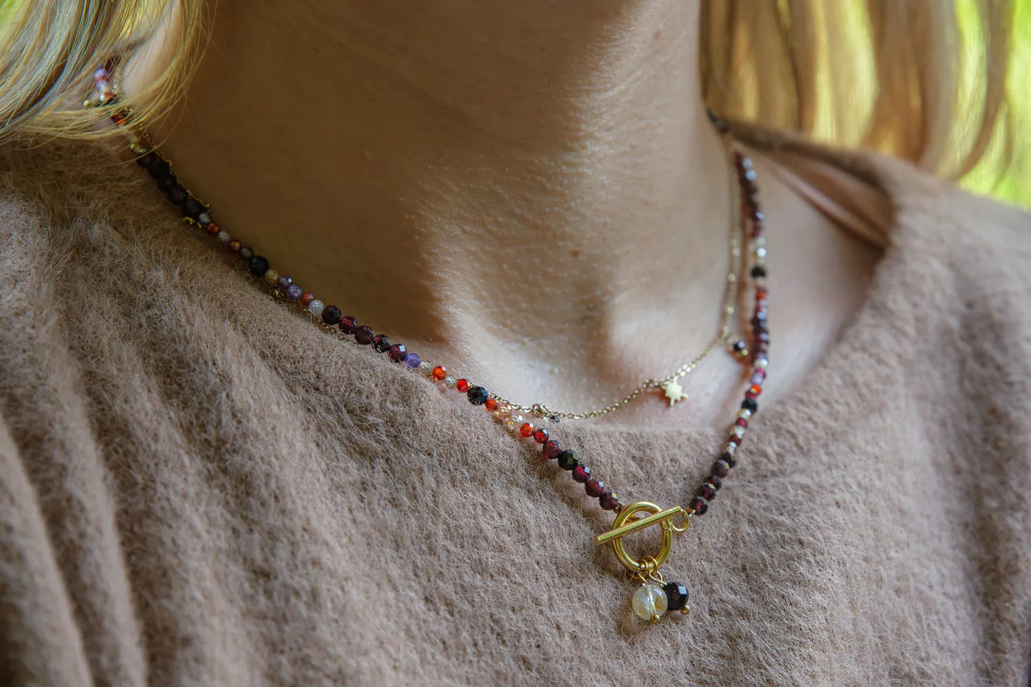 SERCE KRÓLOWEJ - NASZYJNIK Z GRANATU, SPINELU I CYTRYNU, elegancki naszyjnik z kolorowymi kamieniami, ułożony na białym tle z dekoracją w tle.