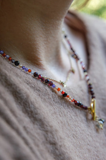 SERCE KRÓLOWEJ - NASZYJNIK Z GRANATU, SPINELU I CYTRYNU, elegancki naszyjnik z kolorowymi kamieniami, ułożony na białym tle z dekoracją w tle.