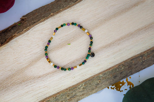 TAJEMNY OGRÓD - BRANSOLETKA Z LEPIDOLITU I CHALCEDONU, złożona z kolorowych koralików lepidolitu i chalcedonu, ułożona na drewnianym tle.