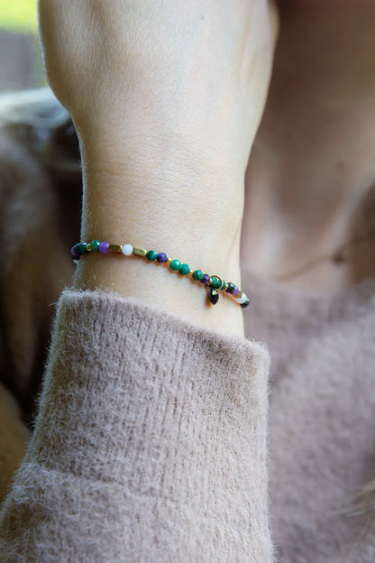 TAJEMNY OGRÓD - BRANSOLETKA Z LEPIDOLITU I CHALCEDONU na nadgarstku, z kolorowymi kamieniami i delikatnym tłem.