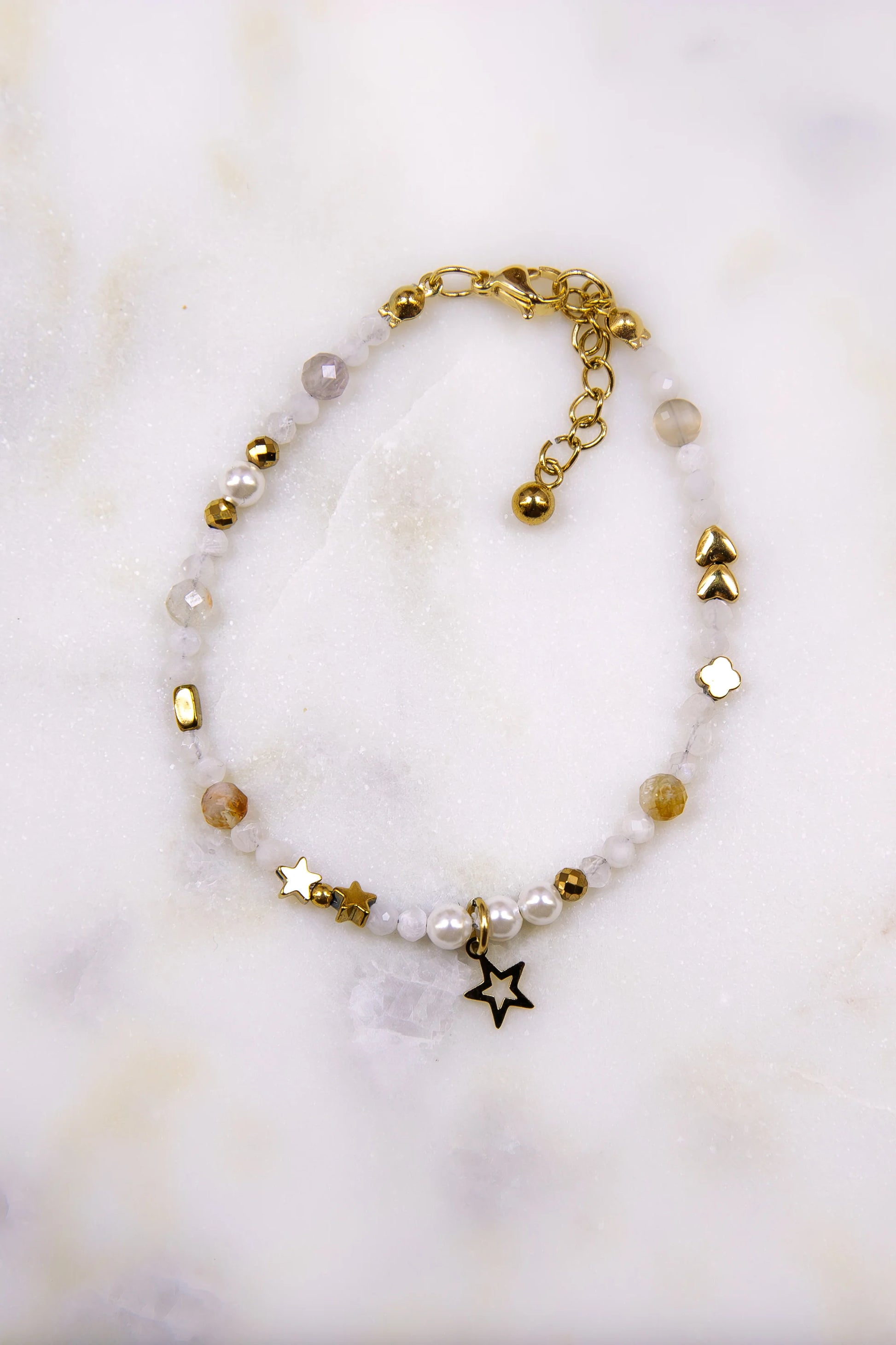 Zbliżenie (makro) na teksturę naturalnych kamieni w bransoletce: iskrzący kamień słoneczny, żółty cytryn, zielony jadeit i opalizująca masa perłowa z przekładkami z hematytu.