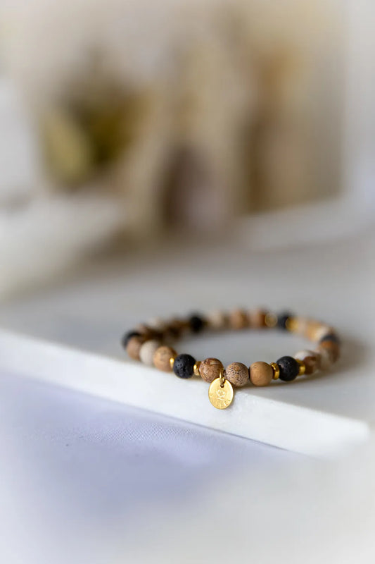 Ziemski Rytm Bransoletka Jaspis Czarna Lawa - zbliżenie na kamienie w beżach i czerni na białym tle